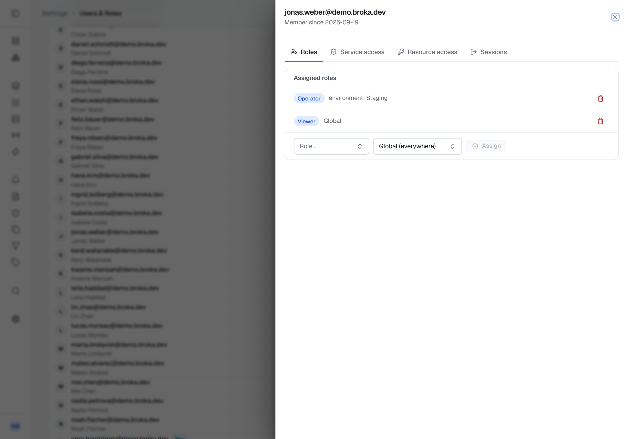 One account's Roles tab: Operator assigned with the scope environment: Staging, Viewer assigned Global, and a row to assign another role with the scope Global (everywhere) preselected.