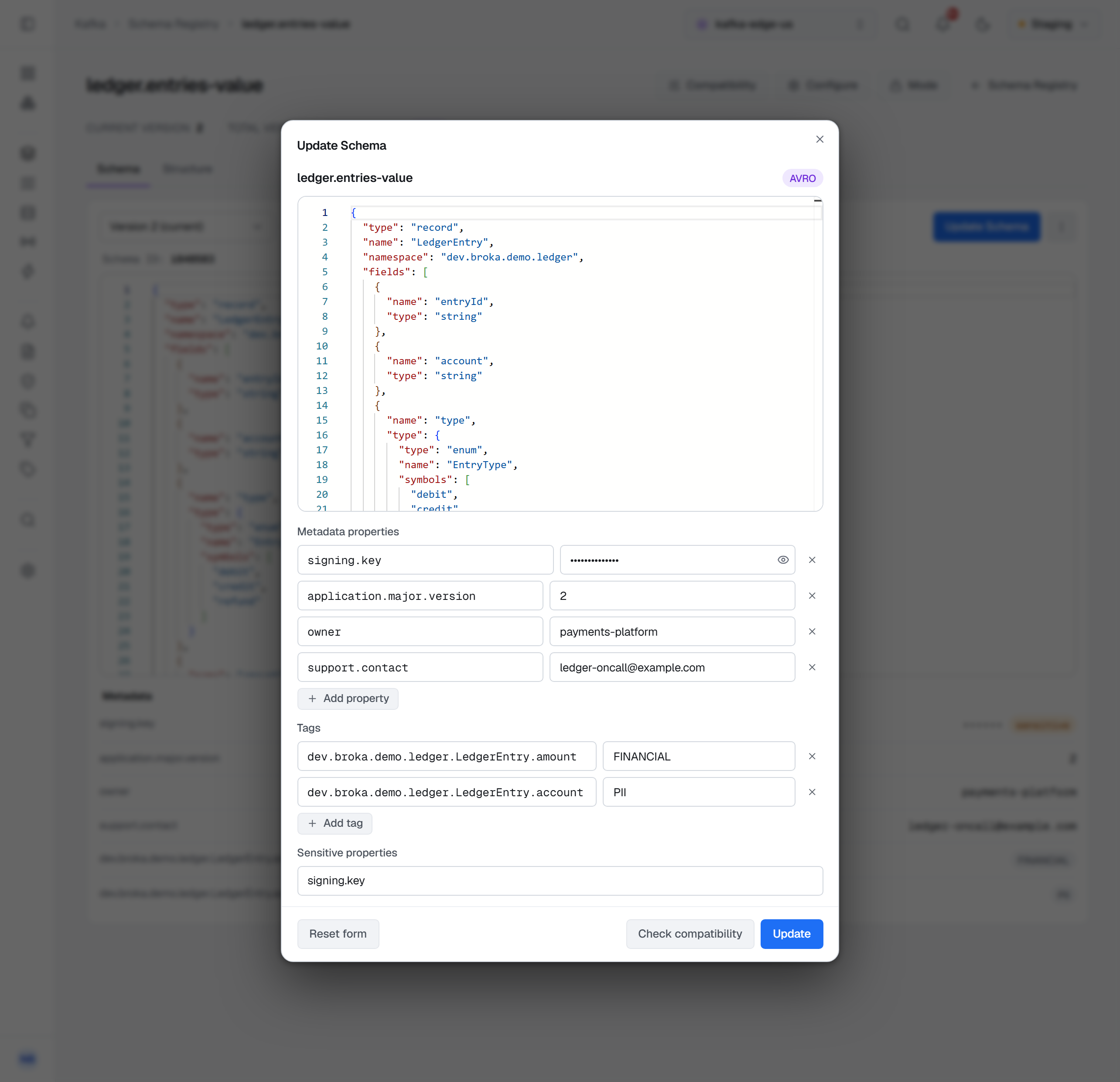 Update Schema for ledger.entries-value, the Avro schema in the editor and, under it, the metadata fields: four Metadata properties — signing.key with its value masked, application.major.version 2, owner payments-platform and support.contact ledger-oncall@example.com — with Add property; two Tags rows, dev.broka.demo.ledger.LedgerEntry.amount with FINANCIAL and dev.broka.demo.ledger.LedgerEntry.account with PII, with Add tag; Sensitive properties reading signing.key; and Reset form, Check compatibility and Update.